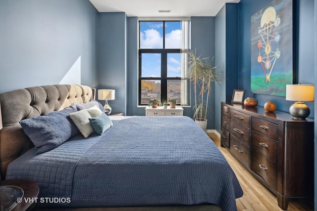 bedroom featuring light wood finished floors and visible vents