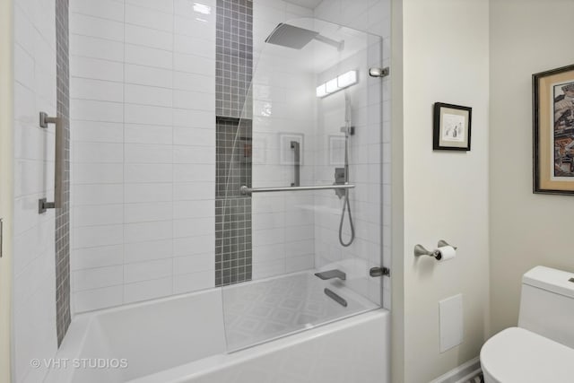 bathroom with combined bath / shower with glass door and toilet