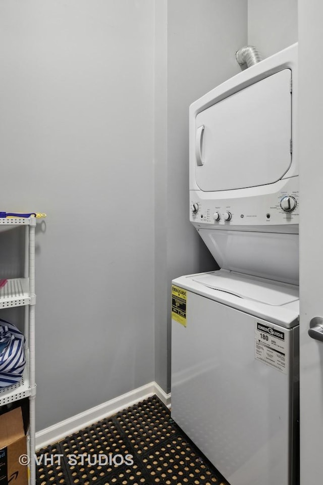 laundry area featuring stacked washer / dryer, laundry area, and baseboards