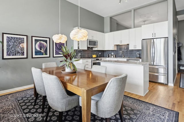 dining area featuring baseboards and light wood-style floors