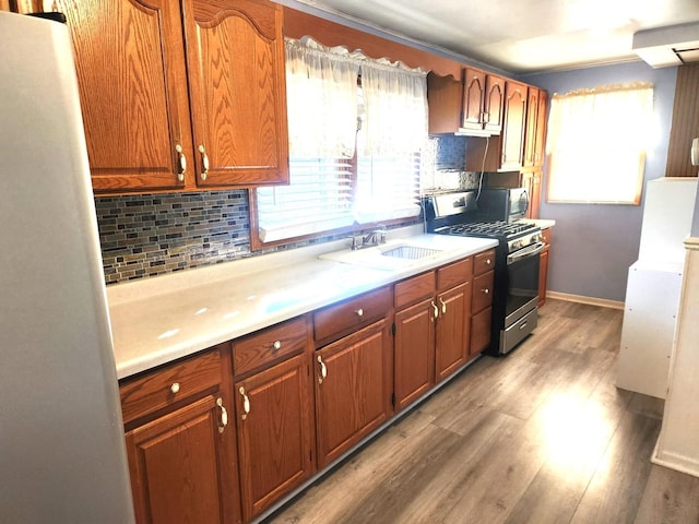 kitchen with stainless steel appliances, a healthy amount of sunlight, light countertops, and decorative backsplash