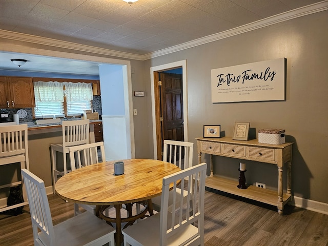 dining space featuring crown molding, dark wood finished floors, and baseboards