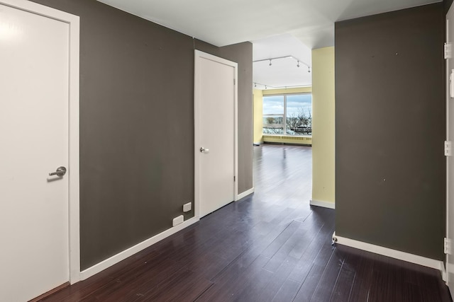 hall featuring dark hardwood / wood-style flooring and track lighting