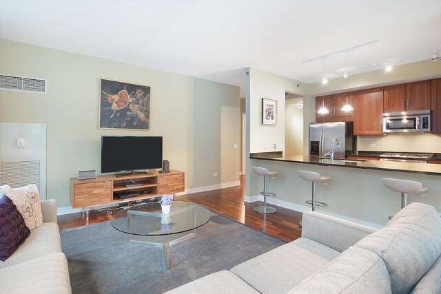 living room featuring sink, track lighting, and dark hardwood / wood-style flooring