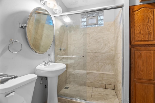 bathroom featuring toilet, a shower with door, and sink