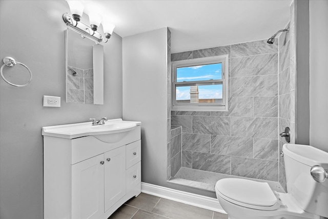 bathroom with tile patterned floors, vanity, toilet, and tiled shower