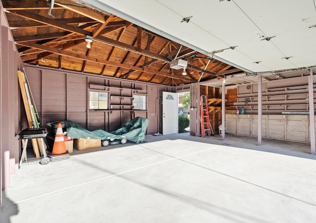 garage with a garage door opener and wood walls