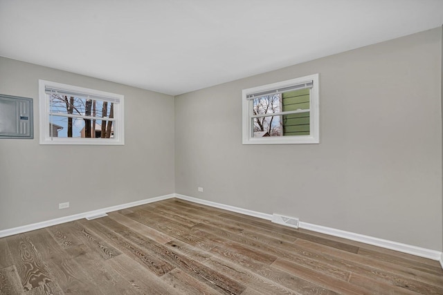 empty room with hardwood / wood-style floors and a wealth of natural light