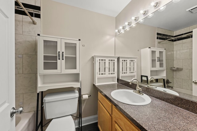 full bathroom featuring tiled shower / bath, vanity, and toilet