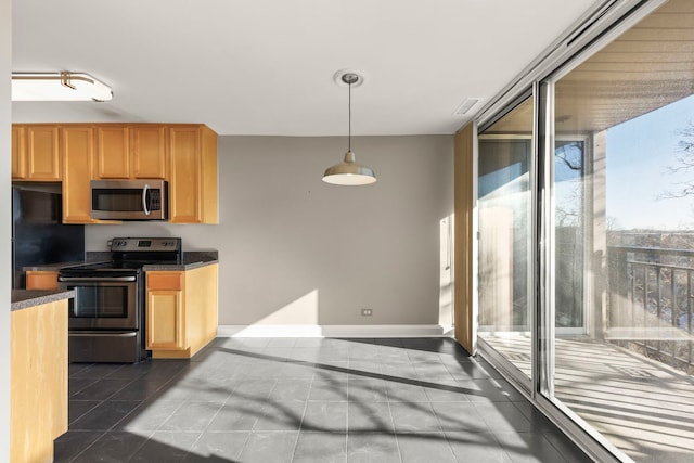 kitchen featuring hanging light fixtures, a wall of windows, stainless steel appliances, and dark tile patterned flooring