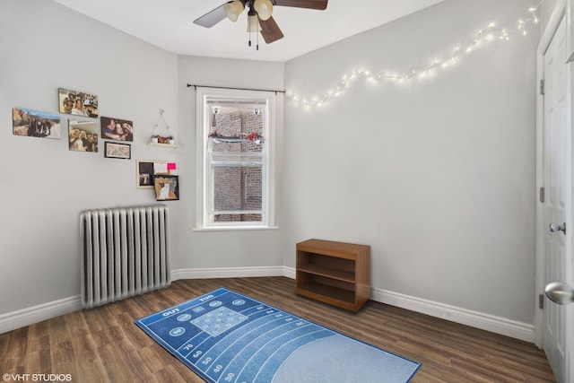 bedroom with radiator, ceiling fan, and dark wood-type flooring