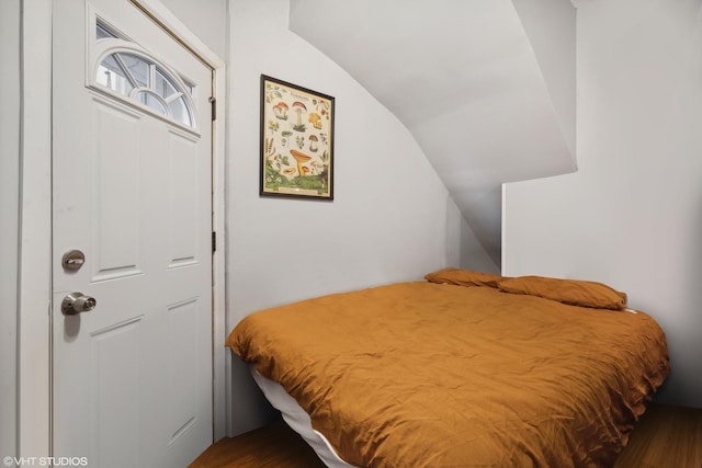 bedroom featuring dark hardwood / wood-style flooring and lofted ceiling