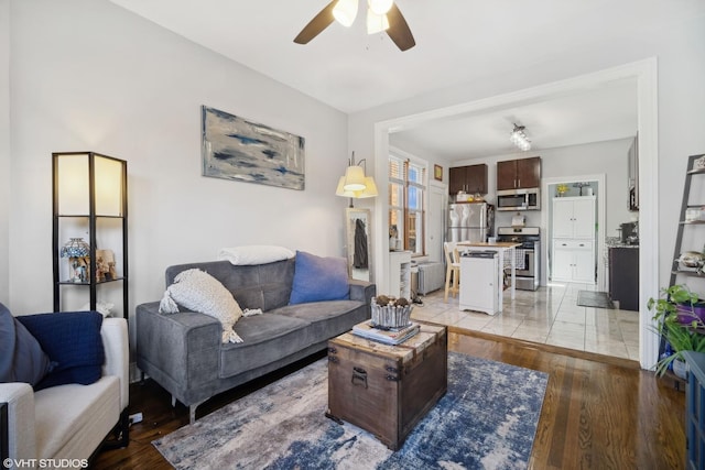 living room featuring ceiling fan and light wood-type flooring