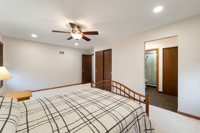 unfurnished bedroom featuring dark colored carpet, ensuite bath, ceiling fan, and a closet