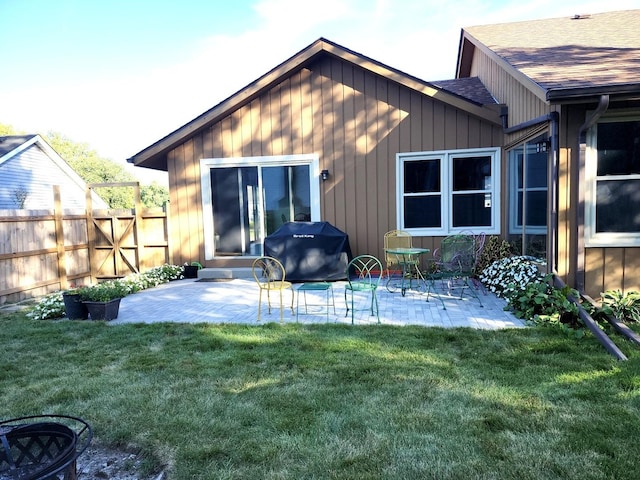 rear view of property featuring a patio and a yard