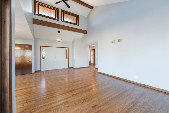 entryway with beamed ceiling, wood-type flooring, ceiling fan, and high vaulted ceiling