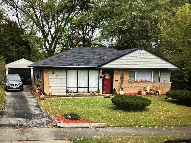 single story home featuring a front lawn, an outdoor structure, and a garage