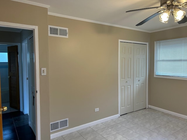 unfurnished bedroom with ceiling fan, light tile patterned floors, crown molding, and a closet