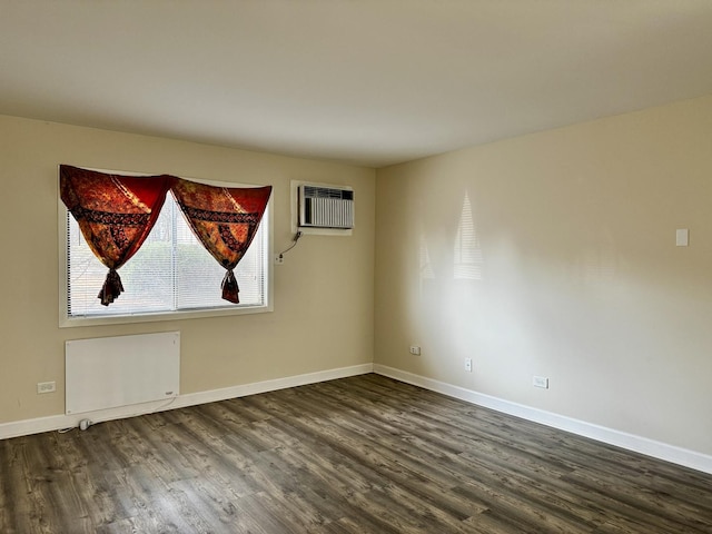 empty room with an AC wall unit, dark hardwood / wood-style flooring, and radiator heating unit