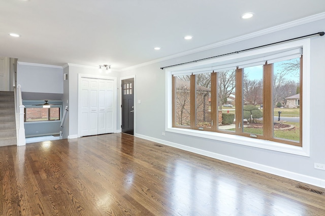 unfurnished living room featuring hardwood / wood-style flooring and crown molding