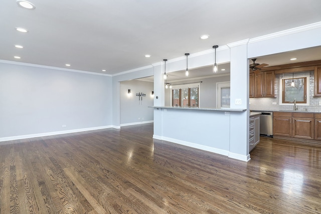 kitchen with backsplash, light stone counters, dark wood-type flooring, sink, and hanging light fixtures