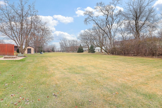 view of yard featuring a fire pit and an outdoor structure