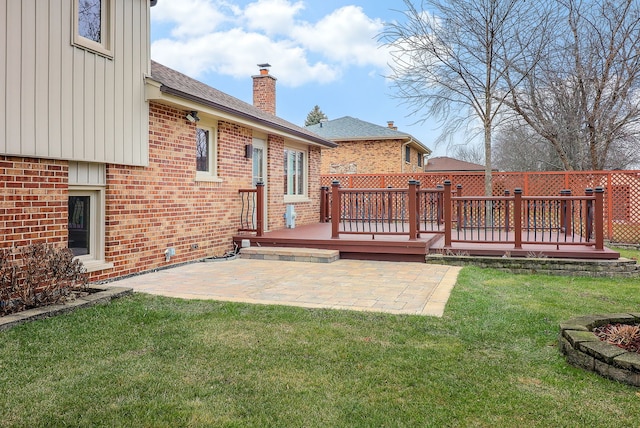 rear view of house with a yard, a patio, and a wooden deck