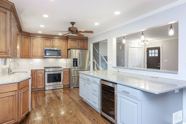 kitchen with sink, light stone countertops, stainless steel appliances, and wine cooler