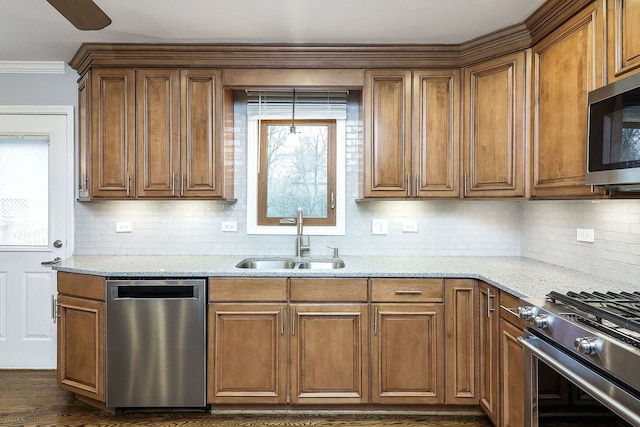 kitchen featuring light stone countertops, appliances with stainless steel finishes, decorative backsplash, dark wood-type flooring, and sink