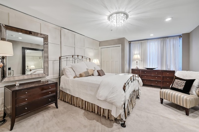 bedroom featuring a closet, recessed lighting, light colored carpet, and a chandelier