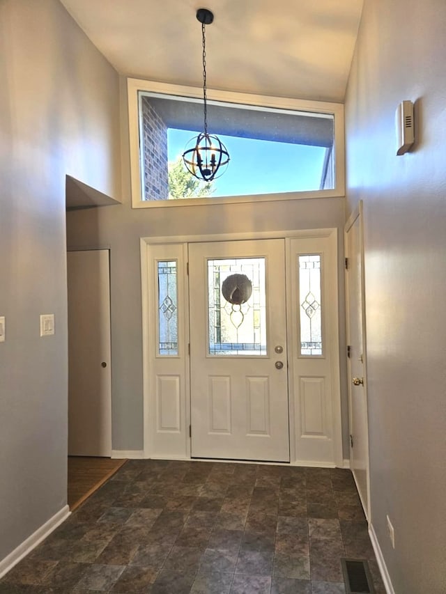 entryway featuring a chandelier and high vaulted ceiling