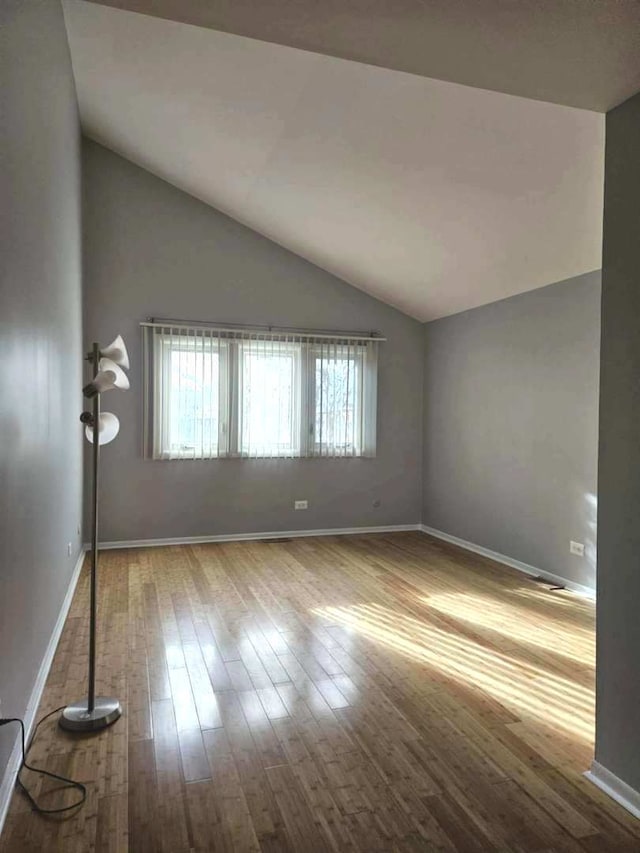 unfurnished room with wood-type flooring and vaulted ceiling