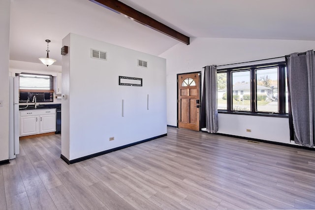 interior space with lofted ceiling with beams, light hardwood / wood-style flooring, and sink