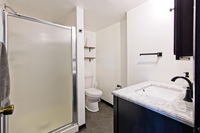 bathroom featuring tile patterned flooring, vanity, a shower with shower door, and toilet