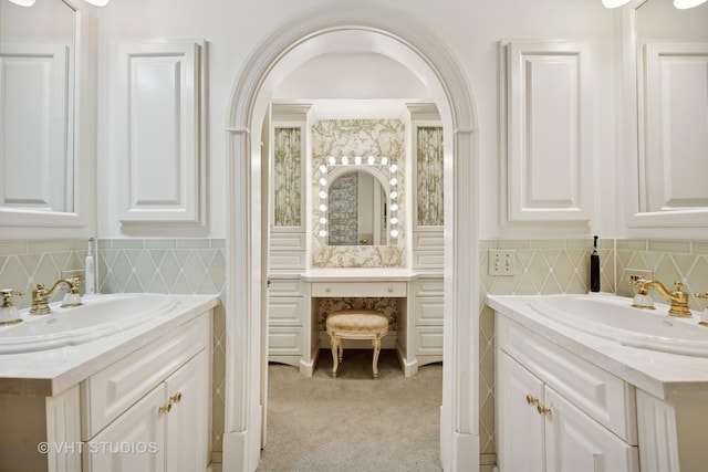 bathroom with a sink, two vanities, and decorative backsplash