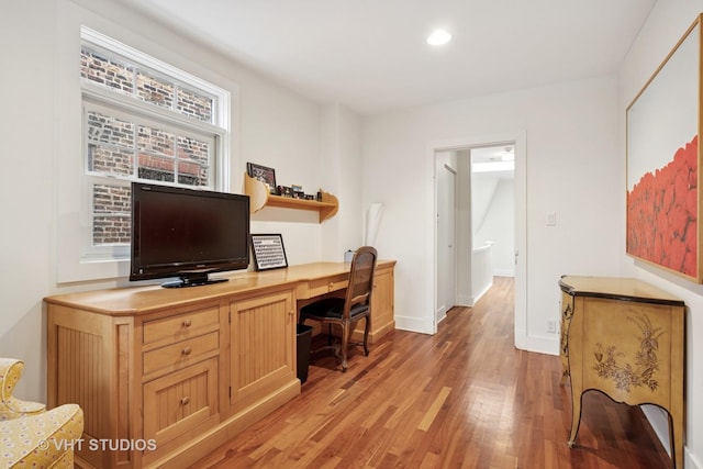 office space with baseboards, built in desk, light wood-style flooring, and recessed lighting