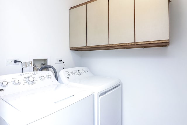 washroom featuring cabinets and separate washer and dryer