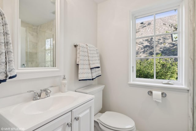 bathroom featuring vanity, toilet, and a shower with shower door