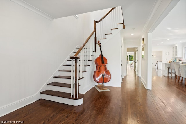 stairs featuring hardwood / wood-style flooring and ornamental molding