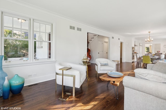 living room with ornamental molding, dark wood-type flooring, and an inviting chandelier