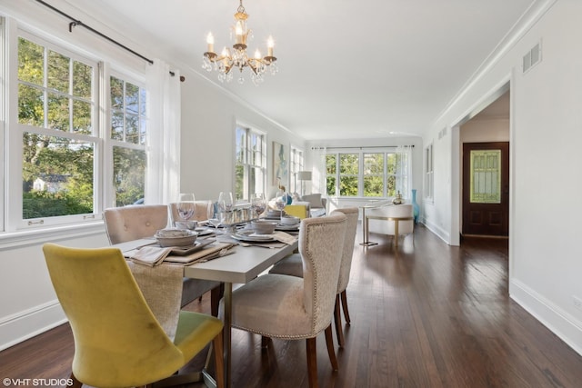 dining room with ornamental molding, an inviting chandelier, and dark hardwood / wood-style flooring