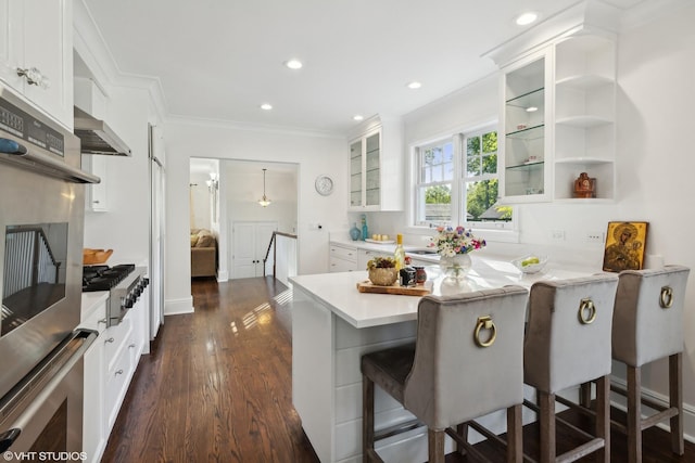 kitchen with white cabinetry, a breakfast bar, and appliances with stainless steel finishes