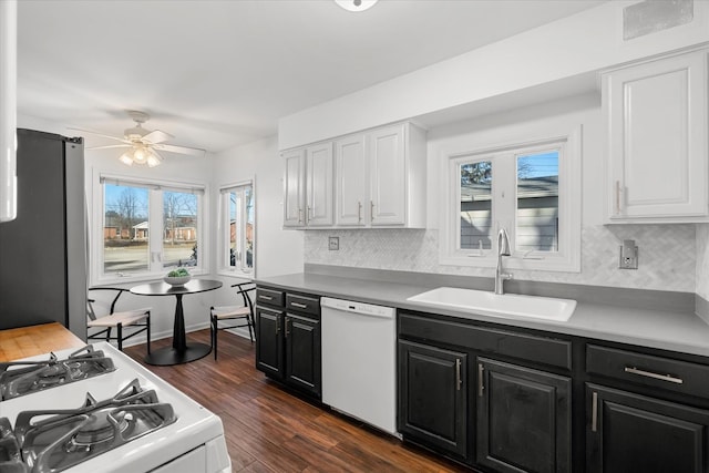 kitchen with sink, white appliances, tasteful backsplash, white cabinets, and dark hardwood / wood-style flooring