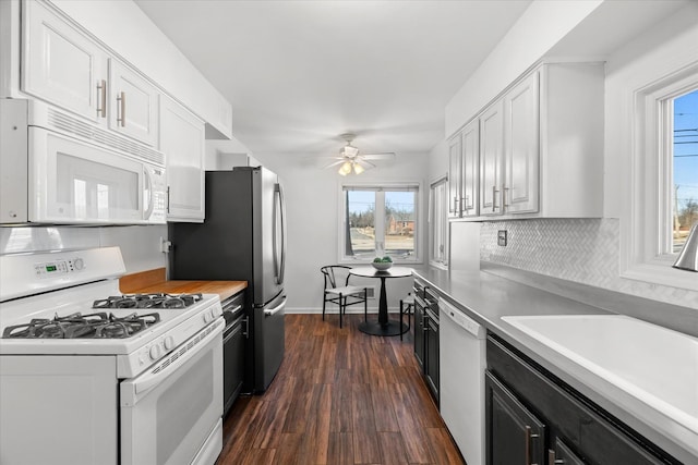 kitchen featuring tasteful backsplash, sink, white cabinets, dark wood-type flooring, and white appliances