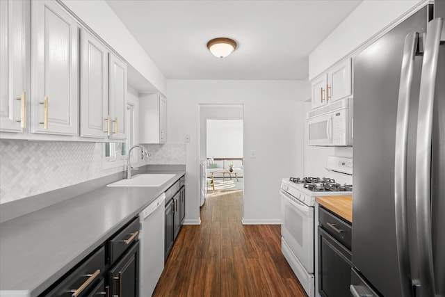 kitchen featuring sink, white appliances, white cabinetry, backsplash, and dark hardwood / wood-style flooring