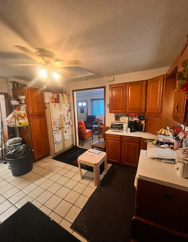 kitchen with ceiling fan, light tile patterned floors, and white fridge