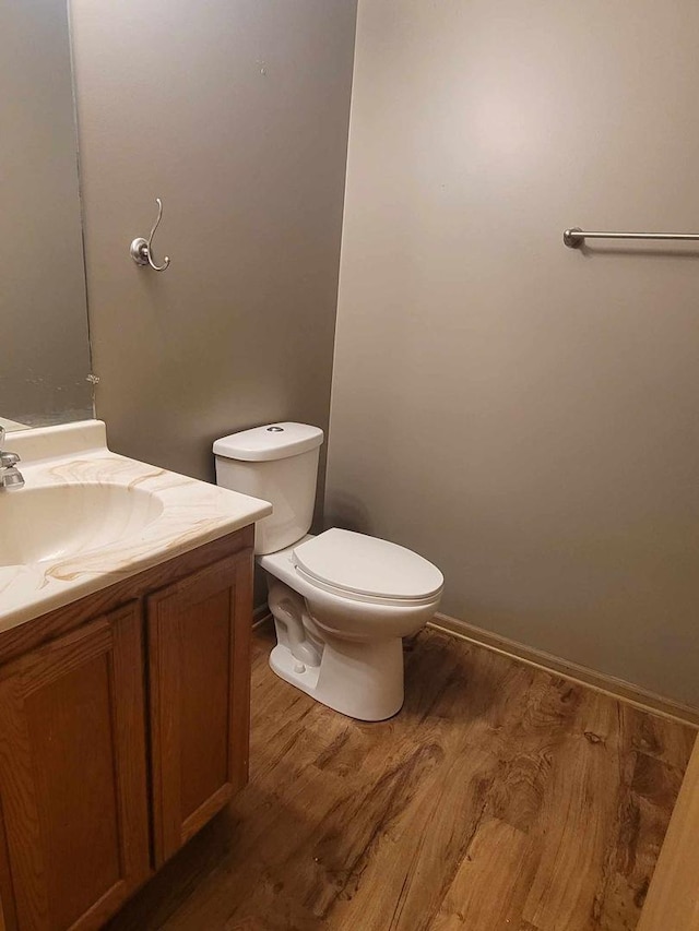 bathroom with hardwood / wood-style floors, vanity, and toilet