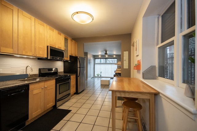 kitchen featuring backsplash, light brown cabinetry, stainless steel appliances, and sink