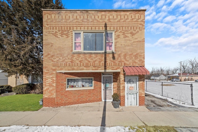 view of front of property with brick siding and fence