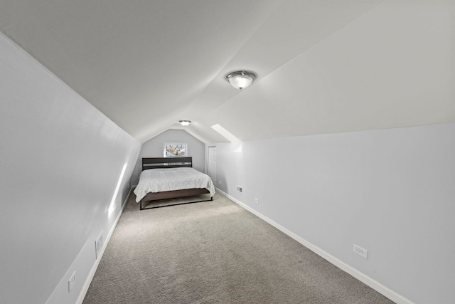 unfurnished bedroom with carpet flooring and vaulted ceiling